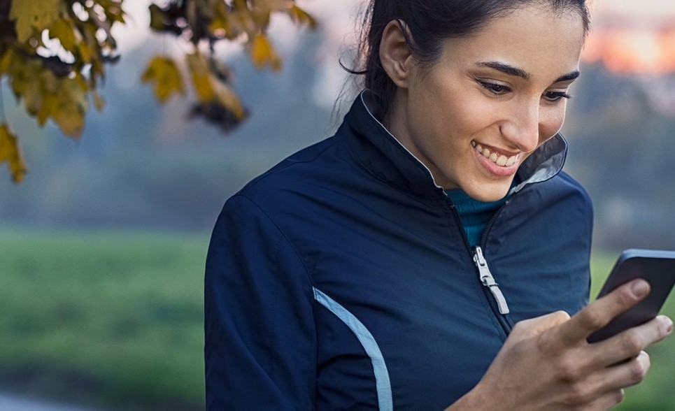 A woman reading a web page on her phone during a run