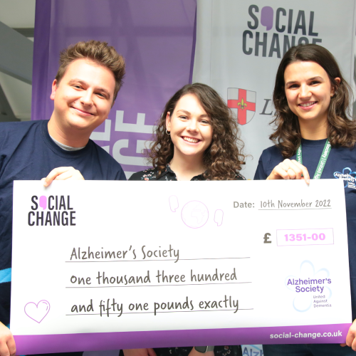 Social Change and Alzheimer's Society holding a giant fundraising cheque